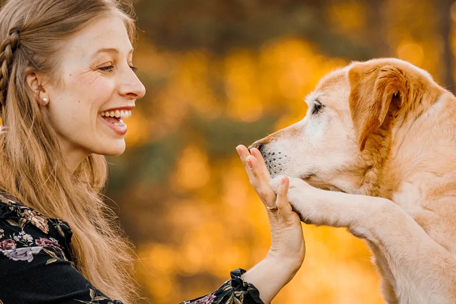 Hundetrainerin und Hund in vertrauenvoller Geste